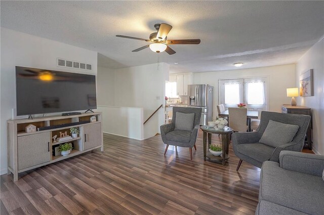 626 N 83rd Ter, Kansas City, KS 66112 - living area featuring dark wood finished floors, visible vents, a ceiling fan, and a textured ceiling