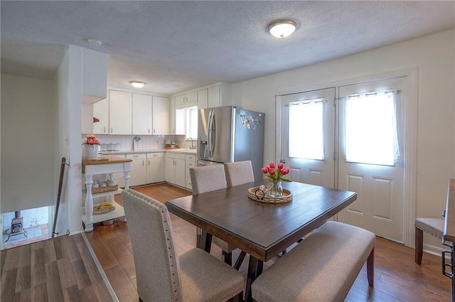 626 N 83rd Ter, Kansas City, KS 66112 - dining space featuring wood finished floors and a textured ceiling