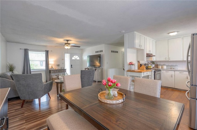626 N 83rd Ter, Kansas City, KS 66112 - dining area with light wood-type flooring, a textured ceiling, a ceiling fan, and visible vents