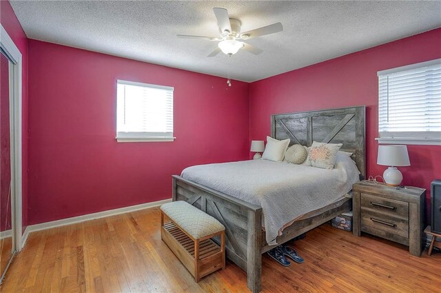 626 N 83rd Ter, Kansas City, KS 66112 - bedroom featuring wood finished floors, a textured ceiling, a ceiling fan, and baseboards
