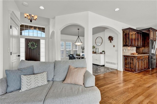 1237 Hillmann Ln, Warrensburg, MO 64093 - living area with a chandelier, light wood finished floors, arched walkways, and recessed lighting