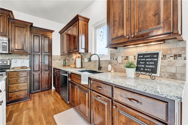 1237 Hillmann Ln, Warrensburg, MO 64093 - kitchen with appliances with stainless steel finishes, light wood finished floors, decorative backsplash, and light stone counters