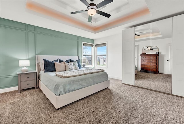 1237 Hillmann Ln, Warrensburg, MO 64093 - carpeted bedroom featuring a tray ceiling and a ceiling fan
