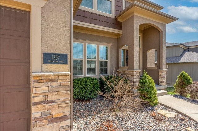 1237 Hillmann Ln, Warrensburg, MO 64093 - doorway to property featuring stucco siding and stone siding