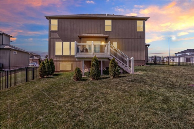 1237 Hillmann Ln, Warrensburg, MO 64093 - back of property at dusk with stairway, a fenced backyard, and a deck