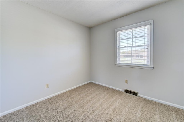 carpeted empty room featuring baseboards and visible vents