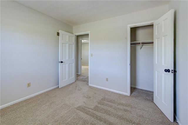 unfurnished bedroom with a closet, carpet flooring, baseboards, and visible vents