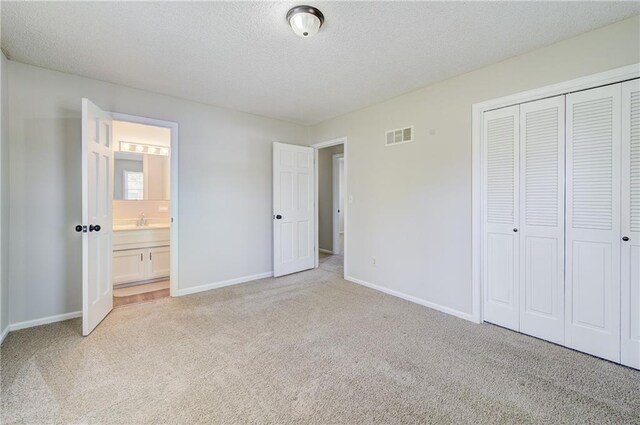 unfurnished bedroom featuring visible vents, baseboards, a closet, and light carpet