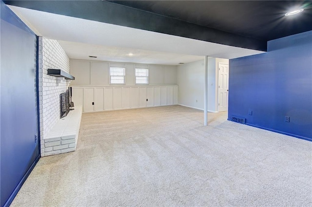 below grade area featuring carpet flooring, a fireplace, and baseboards