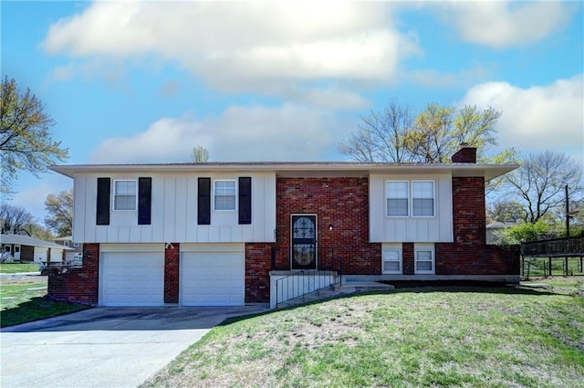 bi-level home with a front yard, brick siding, an attached garage, a chimney, and driveway