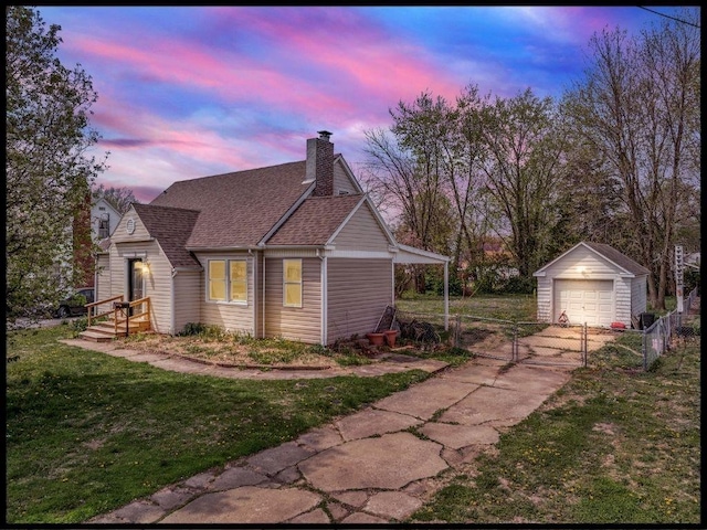 165 S Miami Ave, Marshall, MO 65340 - property exterior at dusk featuring an outdoor structure, a yard, a gate, concrete driveway, and fence