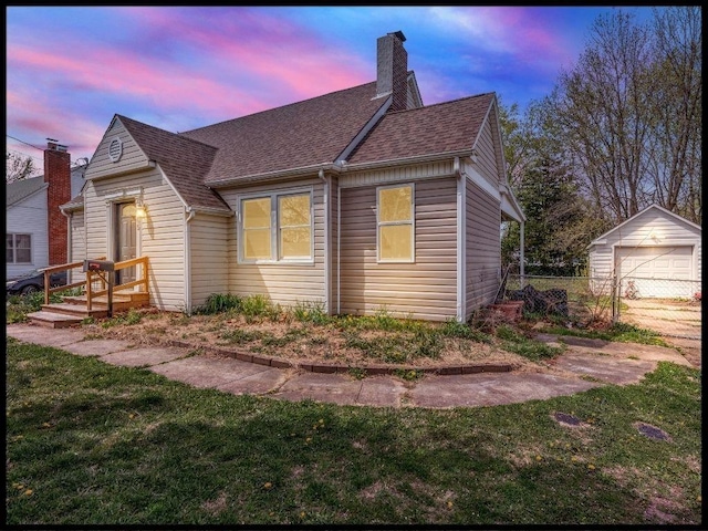 165 S Miami Ave, Marshall, MO 65340 - view of front of property featuring a chimney, fence, a garage, roof with shingles, and a front yard
