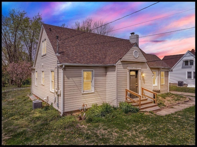 165 S Miami Ave, Marshall, MO 65340 - view of front of home with a chimney, central air condition unit, a front yard, and roof with shingles