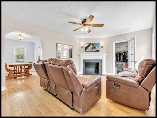 165 S Miami Ave, Marshall, MO 65340 - living room with a fireplace, ceiling fan, light wood-type flooring, and arched walkways