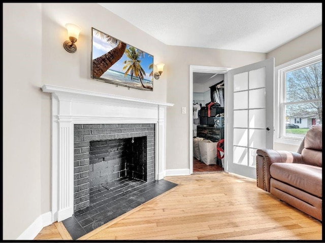 165 S Miami Ave, Marshall, MO 65340 - living area featuring a textured ceiling, wood finished floors, baseboards, and a brick fireplace