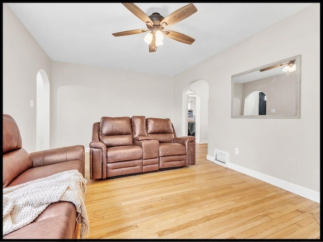 165 S Miami Ave, Marshall, MO 65340 - living room with visible vents, arched walkways, a ceiling fan, and wood finished floors
