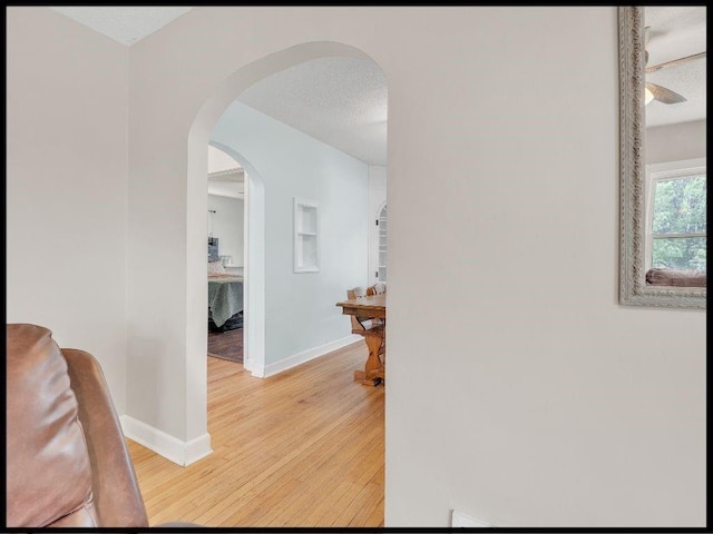 165 S Miami Ave, Marshall, MO 65340 - hall featuring baseboards, arched walkways, a textured ceiling, and light wood finished floors
