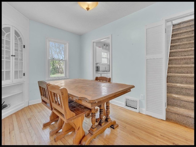 165 S Miami Ave, Marshall, MO 65340 - dining area featuring stairway, visible vents, baseboards, and light wood-style floors