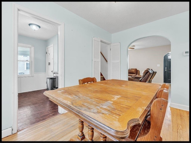 165 S Miami Ave, Marshall, MO 65340 - dining area featuring stairway, wood finished floors, a textured ceiling, and arched walkways