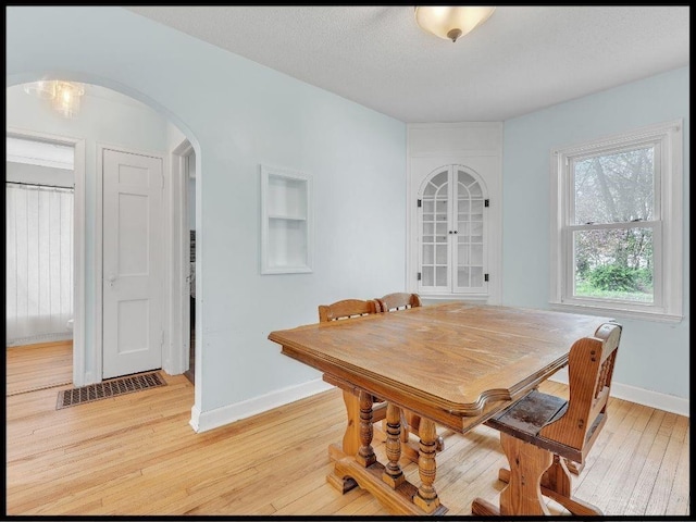 165 S Miami Ave, Marshall, MO 65340 - dining space with baseboards, light wood-type flooring, and arched walkways