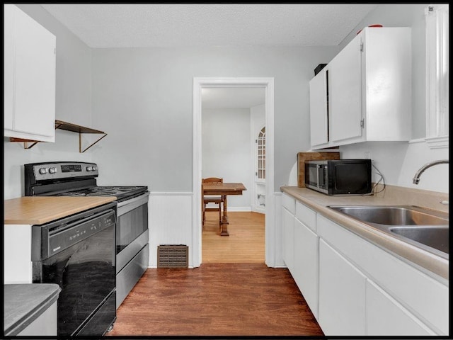 165 S Miami Ave, Marshall, MO 65340 - kitchen with black appliances, dark wood-style flooring, light countertops, and a sink