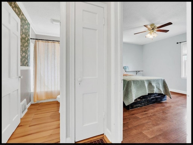 165 S Miami Ave, Marshall, MO 65340 - bedroom with a textured ceiling, crown molding, visible vents, baseboards, and light wood-type flooring