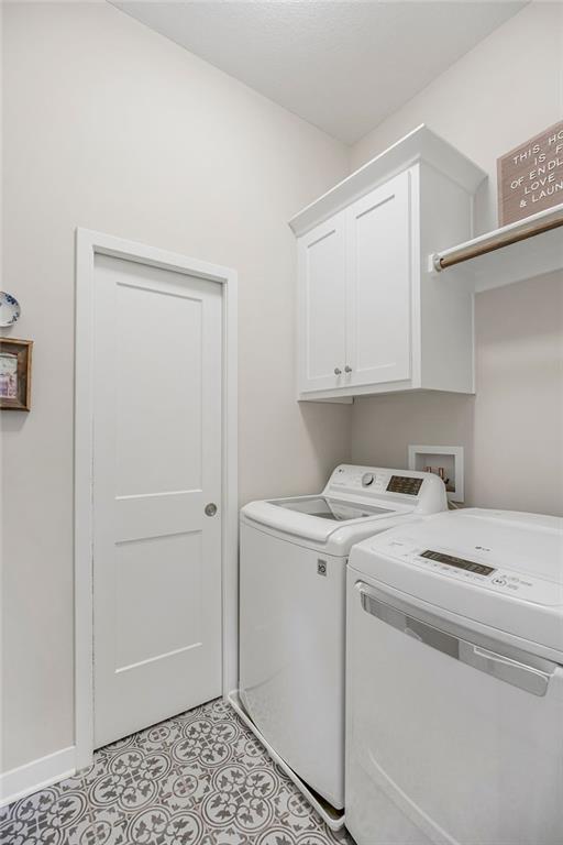 1904 NE 114th Ter, Kansas City, MO 64155 - laundry room featuring cabinet space, baseboards, and washer and dryer