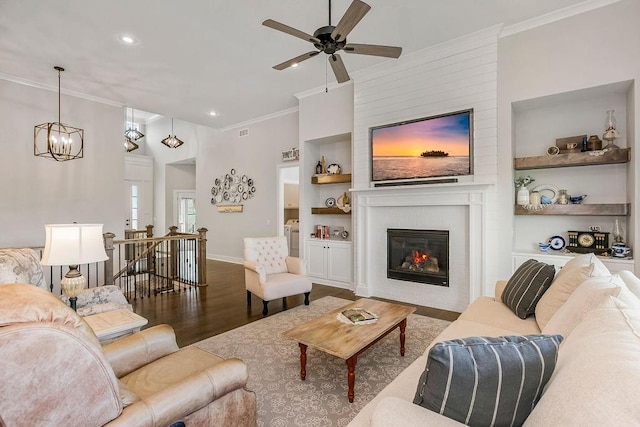 1904 NE 114th Ter, Kansas City, MO 64155 - living area with built in shelves, ceiling fan with notable chandelier, crown molding, and wood finished floors