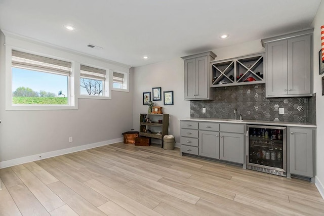 1904 NE 114th Ter, Kansas City, MO 64155 - bar with tasteful backsplash, indoor wet bar, a sink, light wood-type flooring, and wine cooler
