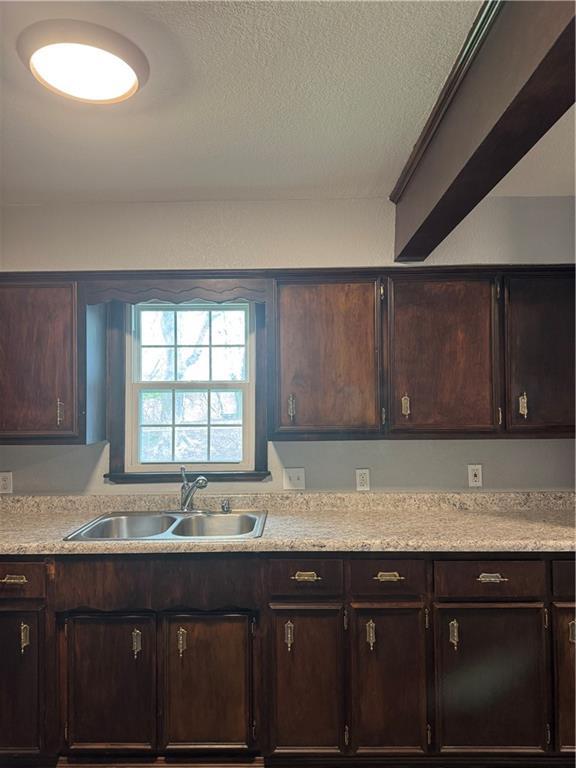 616 Prospect St, Excelsior Springs, MO 64024 - kitchen featuring light countertops, a textured ceiling, and a sink