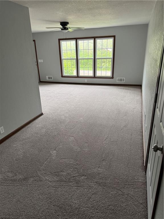 616 Prospect St, Excelsior Springs, MO 64024 - carpeted empty room with visible vents, a ceiling fan, and baseboards