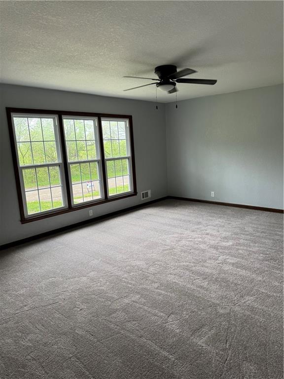 616 Prospect St, Excelsior Springs, MO 64024 - spare room with visible vents, carpet, ceiling fan, and baseboards