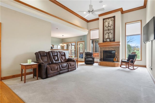 living room with crown molding, a tile fireplace, baseboards, and a wealth of natural light