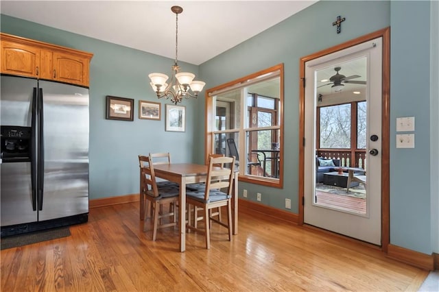 dining room featuring light wood-style floors, an inviting chandelier, and baseboards