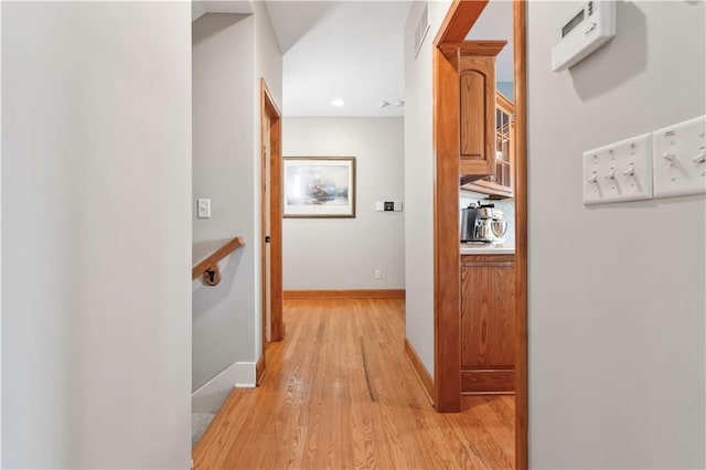 hallway featuring light wood-style flooring and baseboards