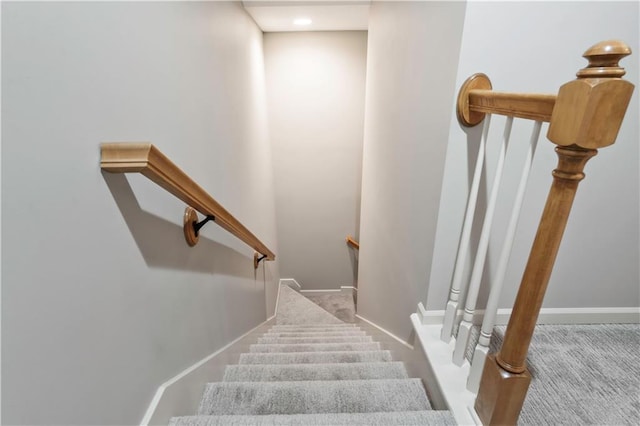 staircase featuring baseboards and carpet floors