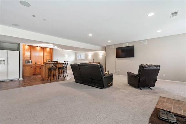 carpeted living room featuring recessed lighting, indoor wet bar, visible vents, and baseboards