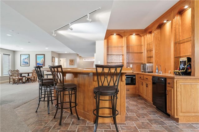 bar featuring stone finish floor, wet bar, dishwasher, a sink, and dark colored carpet