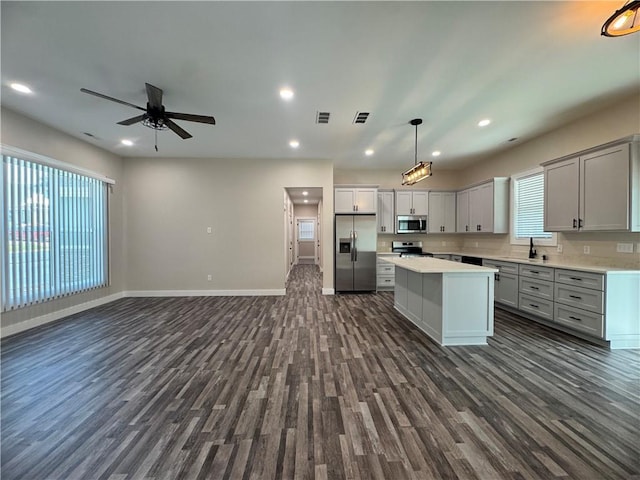 101 N Maple St, Butler, MO 64730 - kitchen featuring appliances with stainless steel finishes, open floor plan, dark wood-style flooring, light countertops, and recessed lighting