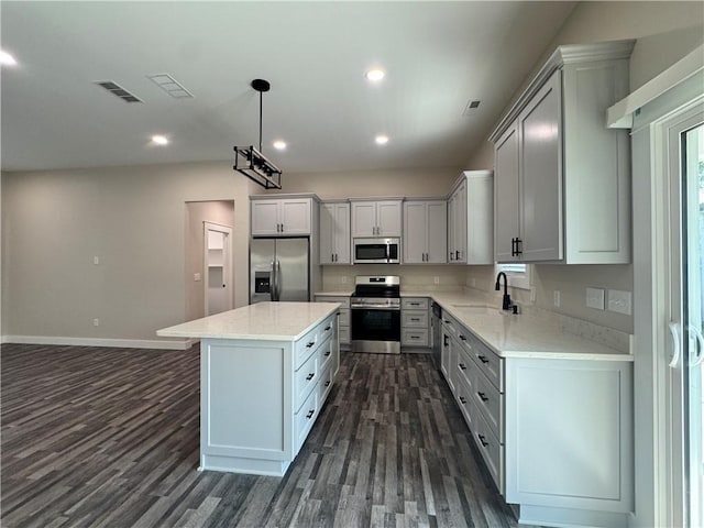 101 N Maple St, Butler, MO 64730 - kitchen featuring stainless steel appliances, a sink, dark wood finished floors, a center island, and baseboards