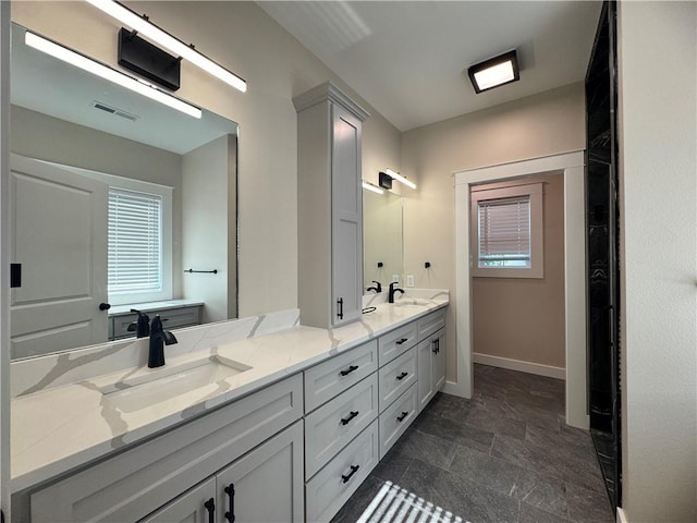 101 N Maple St, Butler, MO 64730 - full bath featuring double vanity, baseboards, stone finish floors, and healthy amount of natural light