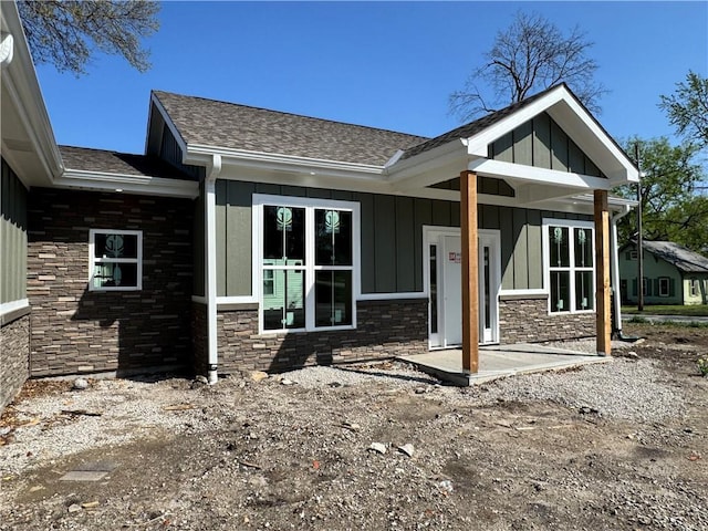 101 N Maple St, Butler, MO 64730 - view of front of property featuring board and batten siding, stone siding, and a shingled roof