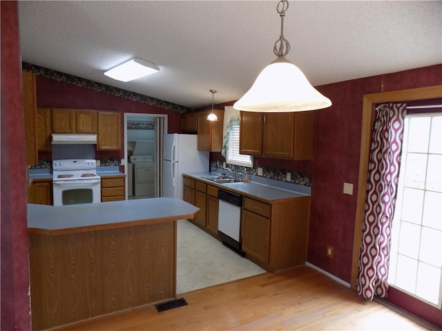 518 S Pine, Ottawa, KS 66067 - kitchen with white appliances, under cabinet range hood, light wood finished floors, washer / dryer, and lofted ceiling