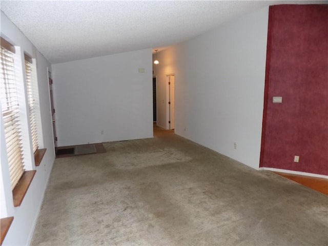 518 S Pine, Ottawa, KS 66067 - unfurnished room with a textured ceiling, vaulted ceiling, and carpet floors
