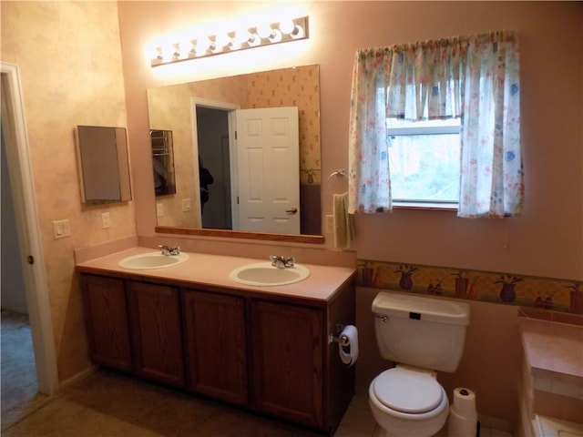 518 S Pine, Ottawa, KS 66067 - bathroom with wallpapered walls, double vanity, a sink, and toilet