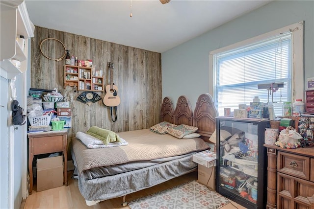 bedroom featuring wooden walls and wood finished floors
