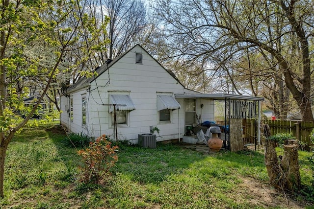 back of property featuring central air condition unit, a yard, and fence