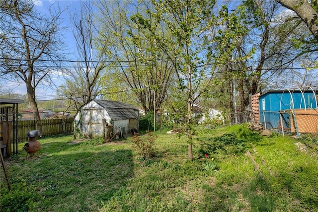 view of yard with a storage shed, a fenced backyard, and an outdoor structure