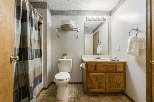 1301 Stonecrest Dr, Kearney, MO 64060 - full bathroom featuring vanity, toilet, stone tile flooring, baseboards, and a textured ceiling