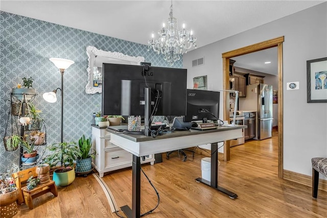 office space with baseboards, an accent wall, light wood finished floors, and wallpapered walls
